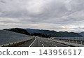 在陰雲密佈的天空下，公路向山脈延伸。 143956517