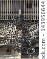 Chaos meets order in an Asian cityscape as a messy web of black utility wires and communication cables cuts across a beautiful, modern geometric concrete and wooden building facade. 143956644