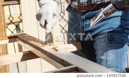 Carpenter at work, restoring an old wooden window. Carpentry. Carpenter at work, restoring an old wooden window. Carpentry. 143957596