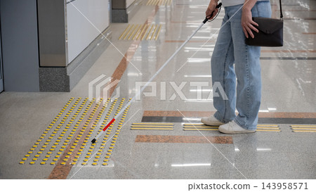 A blind woman waits for a train on the subway. A blind woman waits for a train on the subway. 143958571