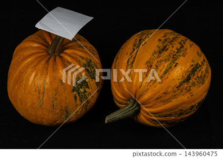Two pumpkins on a dark background for Halloween and autumn decoration 143960475
