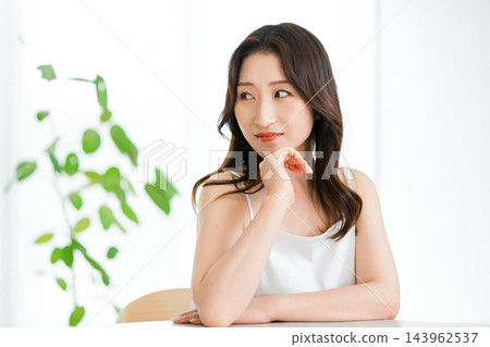 女子放鬆地托著下巴的美麗肖像。 女子放鬆地托著下巴的美麗肖像。 143962537