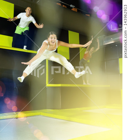 Excited young girl jumping at indoor trampoline center 143962913