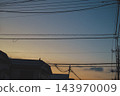 Power lines and utility poles stretched across a residential area at dusk. 143970009