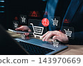 E-commerce fraud security and online shopping risk concept. Buyer typing on laptop and holding smartphone with shopping cart, warning sign, payment transaction error, digital retail cyber threat alert 143970669