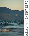 People swim in Danang sea, Lady Buddha statue and Linh Ung Pagoda above waves and tourists in Da Nang, Coastal view of Son Tra Peninsula with Buddhist landmark, mountains and ocean shoreline 143971279