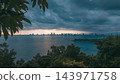 dramatic storm clouds over coastal Da Nang city skyline during sunset over sea, dark tropical weather approaching urban bay featuring panoramic ocean view of Danang 143971758