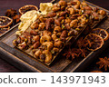 A bar of sugar free white chocolate with pistachios, almonds, and hazelnuts. A white chocolate bar 143971943