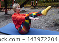 Mature woman practicing yoga and stretching outdoors in an autumn park. Active senior enjoying healthy aging, fitness, and vitality through outdoor workout and mindfulness. 143972204