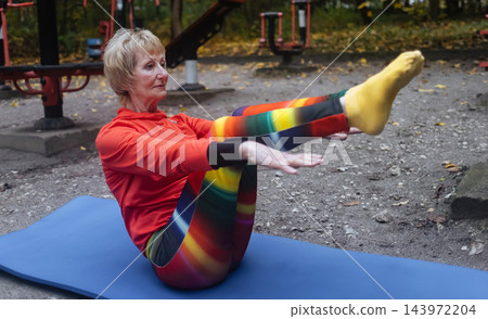 Mature woman practicing yoga and stretching outdoors in an autumn park. Active senior enjoying healthy aging, fitness, and vitality through outdoor workout and mindfulness. Mature woman practicing yoga and stretching outdoors in an autumn park. Active senior enjoying healthy aging, fitness, and vitality through outdoor workout and mindfulness. 143972204