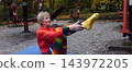 Mature woman practicing yoga and stretching outdoors in an autumn park. Active senior enjoying healthy aging, fitness, and vitality through outdoor workout and mindfulness. 143972205
