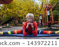 Mature woman practicing yoga and stretching outdoors in an autumn park. Active senior enjoying healthy aging, fitness, and vitality through outdoor workout and mindfulness. 143972211