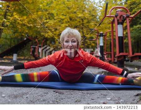 Mature woman practicing yoga and stretching outdoors in an autumn park. Active senior enjoying healthy aging, fitness, and vitality through outdoor workout and mindfulness. Mature woman practicing yoga and stretching outdoors in an autumn park. Active senior enjoying healthy aging, fitness, and vitality through outdoor workout and mindfulness. 143972213
