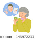 Senior woman receives thank-you messages from grandchildren on her smartphone during the New Year's holiday. 143972233