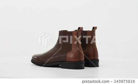 Pair of brown leather Chelsea boots for men with elastic side panels and pull tabs, elegant classic footwear Pair of brown leather Chelsea boots for men with elastic side panels and pull tabs, elegant classic footwear 143973819