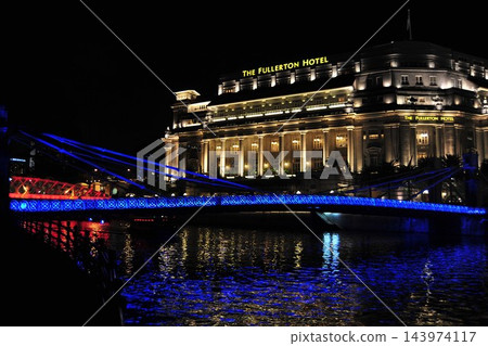 新加坡富麗敦飯店的夜景,以及燈光璀璨的藍色大橋。 新加坡富麗敦飯店的夜景,以及燈光璀璨的藍色大橋。 143974117