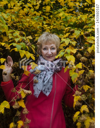Happy senior woman in pink coat smiling outdoors in autumn park. Active elderly lifestyle, healthy aging and seasonal wellness concepts. Happy senior woman in pink coat smiling outdoors in autumn park. Active elderly lifestyle, healthy aging and seasonal wellness concepts. 143980587