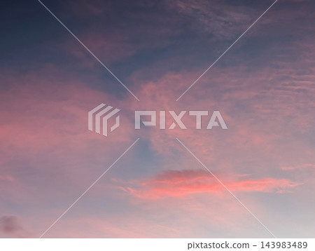 柔和的天空背景,淡粉紅色的雲朵散佈在藍灰色的天空中。 柔和的天空背景,淡粉紅色的雲朵散佈在藍灰色的天空中。 143983489