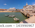 Fishing Boats in Cascais Harbor with Sandy Beach and Waterfront, Portugal 143990967