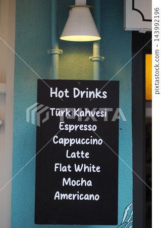 Chalkboard lists hot drinks at a cafe in an indoor setting Chalkboard lists hot drinks at a cafe in an indoor setting 143992196