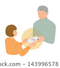 A senior man hands his granddaughter New Year's money directly to her. 143996578