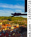 Unique dragon-headed drain pipe overlooks a scenic view of the historic old town 143997718