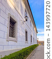 A white Renaissance building facade with sgraffito wall decor, grated windows 143997720