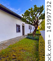 The image shows a white traditional building with a dark-framed window and door 143997732