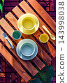 Tableware placed on a wooden table, viewed from above. 143998038
