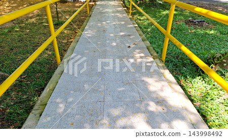 Park Pathway with Yellow Safety Railings Park Pathway with Yellow Safety Railings 143998492