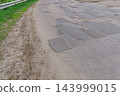 Patched Rural Road With Guardrail And Grass 143999015