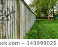 Weathered Wooden Fence Panels Along Path 143999026