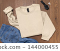 Blank beige unisex sweatshirt mockup, folded crewneck flat lay with denim jeans and mens accessories 144000455