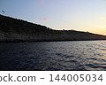 Rocky limestone coastline of small Adriatic island with seagulls colony at dusk 144005034