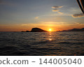 Clean golden sunset path on Adriatic Sea with island silhouette and mountain coast 144005040