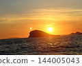 Double sun effect at sunset over Adriatic Sea with rocky island silhouette near Cavtat 144005043