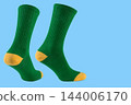 Pair of green sports socks with yellow heel on blue background, athletic promo banner mockup with copy space 144006170