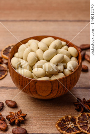 Sweet white colored candy dragees with peanuts. Sweet peanut filled dragees Sweet white colored candy dragees with peanuts. Sweet peanut filled dragees 144012170