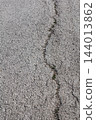 Cracked dry asphalt surface close up view. 144013862
