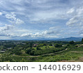 A winding road through green hills, a wide sky, and a peaceful rural landscape. A winding road through green hills, a wide sky, and a peaceful rural landscape. 144016929