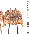 Roasted whole chicken carcass on skewer against white background 144018361