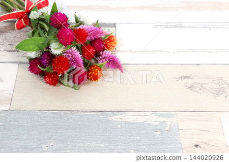 一束色彩艷麗的千日紅花,背景是木紋。 一束色彩艷麗的千日紅花,背景是木紋。 144020926