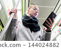 Young woman passenger using smartphone while moving in the modern metro, commuting by public transport. 144024882
