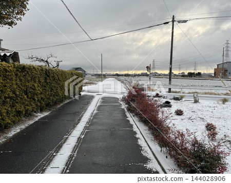 冬日的天空下,一條公路蜿蜒穿過白雪皚皚的鄉村。 冬日的天空下,一條公路蜿蜒穿過白雪皚皚的鄉村。 144028906