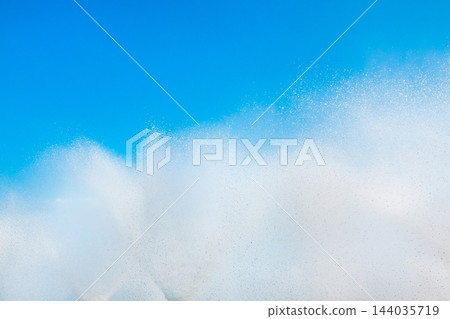 A fountain splashes and drops against a beautiful, bright, blue sky background A fountain splashes and drops against a beautiful, bright, blue sky background 144035719