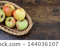 Apples in a basket against a wooden background 144036107