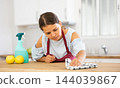 Positive housewife cleans table in home kitchen 144039867