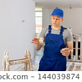 Frustrated fifteen-year-old worker counts his first salary 144039874