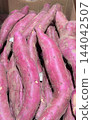 Fresh sweet potatoes lined up in cardboard boxes 144042507