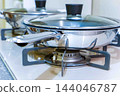 A frying pan placed on a gas stove 144046787